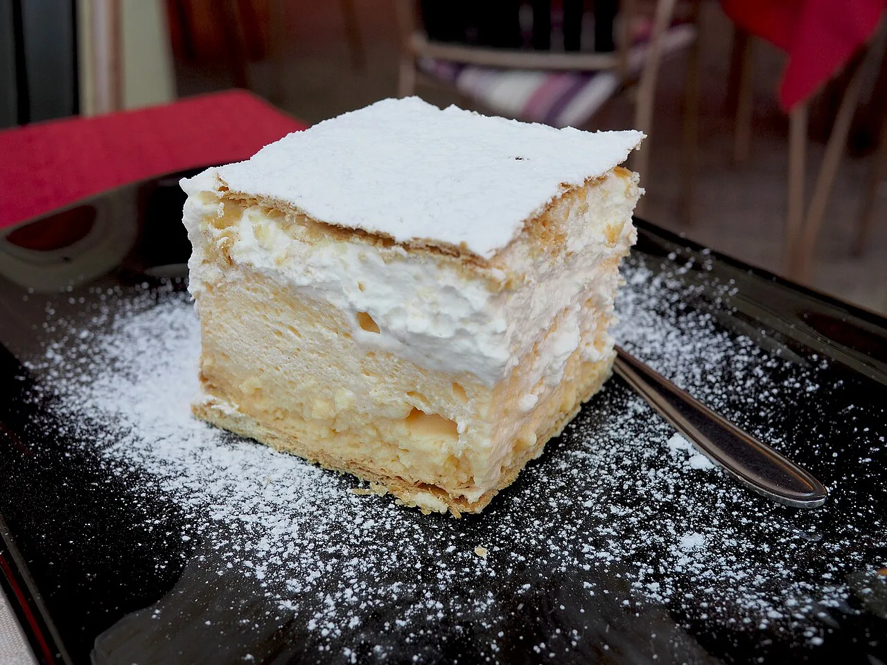 Bled cream cake (kremšnita) dusted with sugar.
