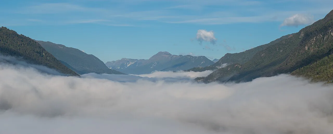Fog over the Soča valley with mountains above.