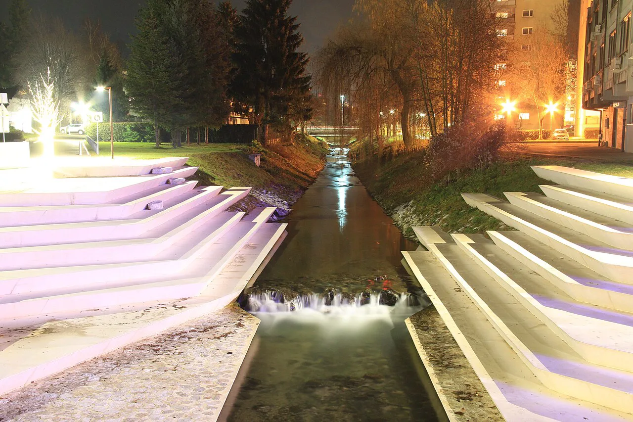 The lit river steps in central Velenje at night.