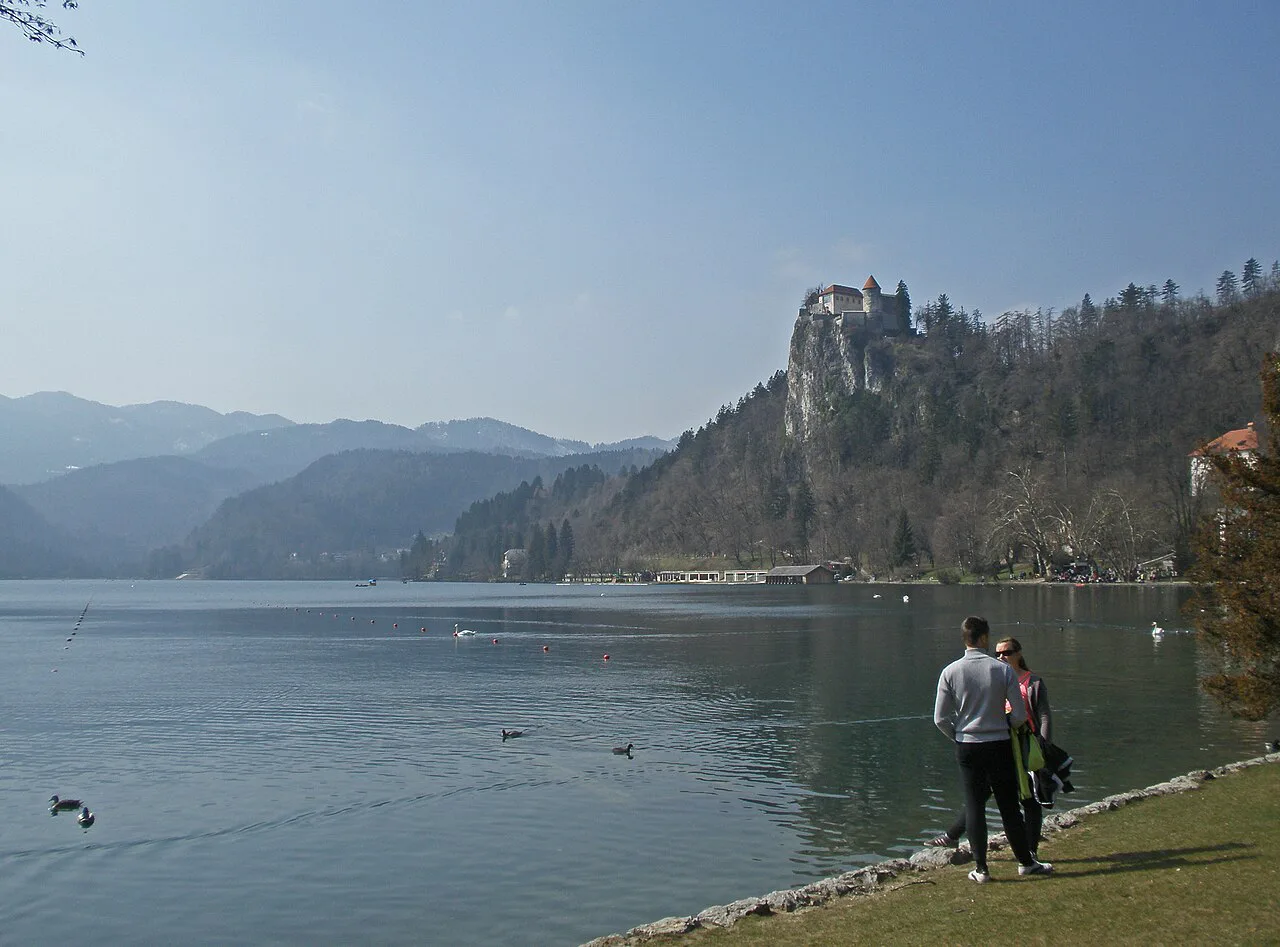 Walkers on the Lake Bled lakeside below the castle.
